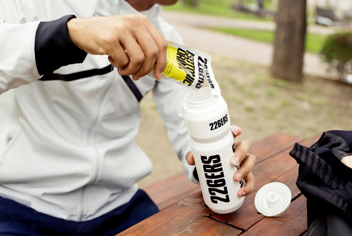Imagen de atleta utilizando isotonic drink en un bidón de agua